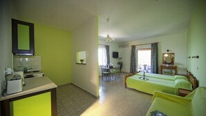 Une chambre avec un coin cuisine, un espace repas et un lit.