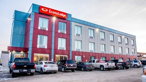 Un hôtel à plusieurs étages, avec une façade rouge et bleue, de nombreuses places de stationnement et une enseigne bien visible indiquant « EconoLodge ».