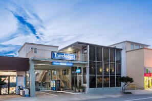 A Travelodge hotel with a modern facade, an office sign, and a visible staircase leading to the entrance. - Travelodge by Wyndham Virginia Beach (Virginia Beach)