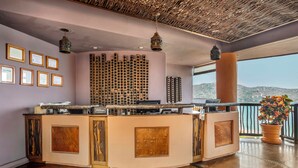 A hotel lobby with a reception desk, framed certificates on the wall, a decorative ceiling, and a view of the sea. - Hilton Grand Vacations Club Zihuatanejo (Zihuatanejo)