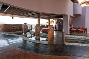 A hotel lobby with a curved ceiling, a staircase, and a sign that reads 'EMBARC'. - Hilton Grand Vacations Club Zihuatanejo (Zihuatanejo)