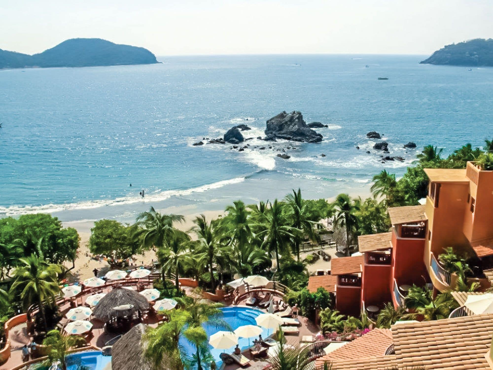 Un resort con piscina, playa y vista al océano.