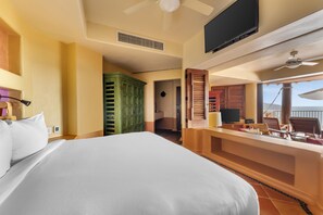 A hotel room with a bed, a television, a desk with a chair, and a view of the outdoors. - Hilton Grand Vacations Club Zihuatanejo (Zihuatanejo)