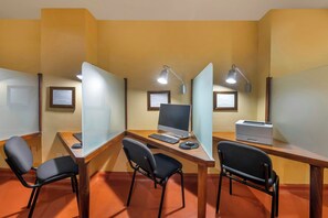 Un espace de travail doté de bureaux individuels, chacun étant équipé d’un ordinateur, d’un clavier et d’une souris.