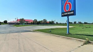 A motel sign with '6' and 'ALL NEW ROOMS' indicating new accommodations.
