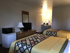 A hotel room with two beds, a desk with a microwave, a television, and a mirror. - Super 8 by Wyndham Hurricane Zion National Park (Hurricane)