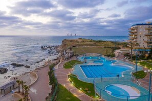 Un complexe hôtelier doté d’une grande piscine, d’une plage et offrant une vue sur l’océan.