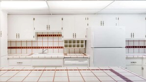 Eine moderne Küche mit weißen Schränken, einem eingebauten Backofen und einer gefliesten Spritzschutzwand.
