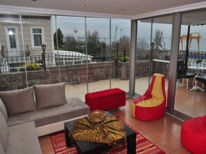 A modern living room with a sofa, red bean bag, and a decorative bowl on a table. - Harmony Istanbul (Istanbul)