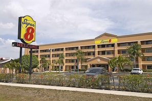 Un hotel Super 8 con un cartello che recita 'Benvenuti', diversi piani e un parcheggio.