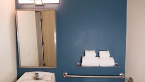 A bathroom with a sink, toilet, mirror, and towel rack. - Suburban Studios Lakeland North I-4 (Lakeland)