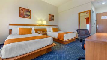 Habitación de hotel con dos camas, un escritorio y una silla.