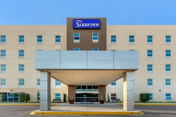 A Sleep Inn hotel with a central entrance, multiple windows, and a clear sky. - Hotel Torreon (Torreón)