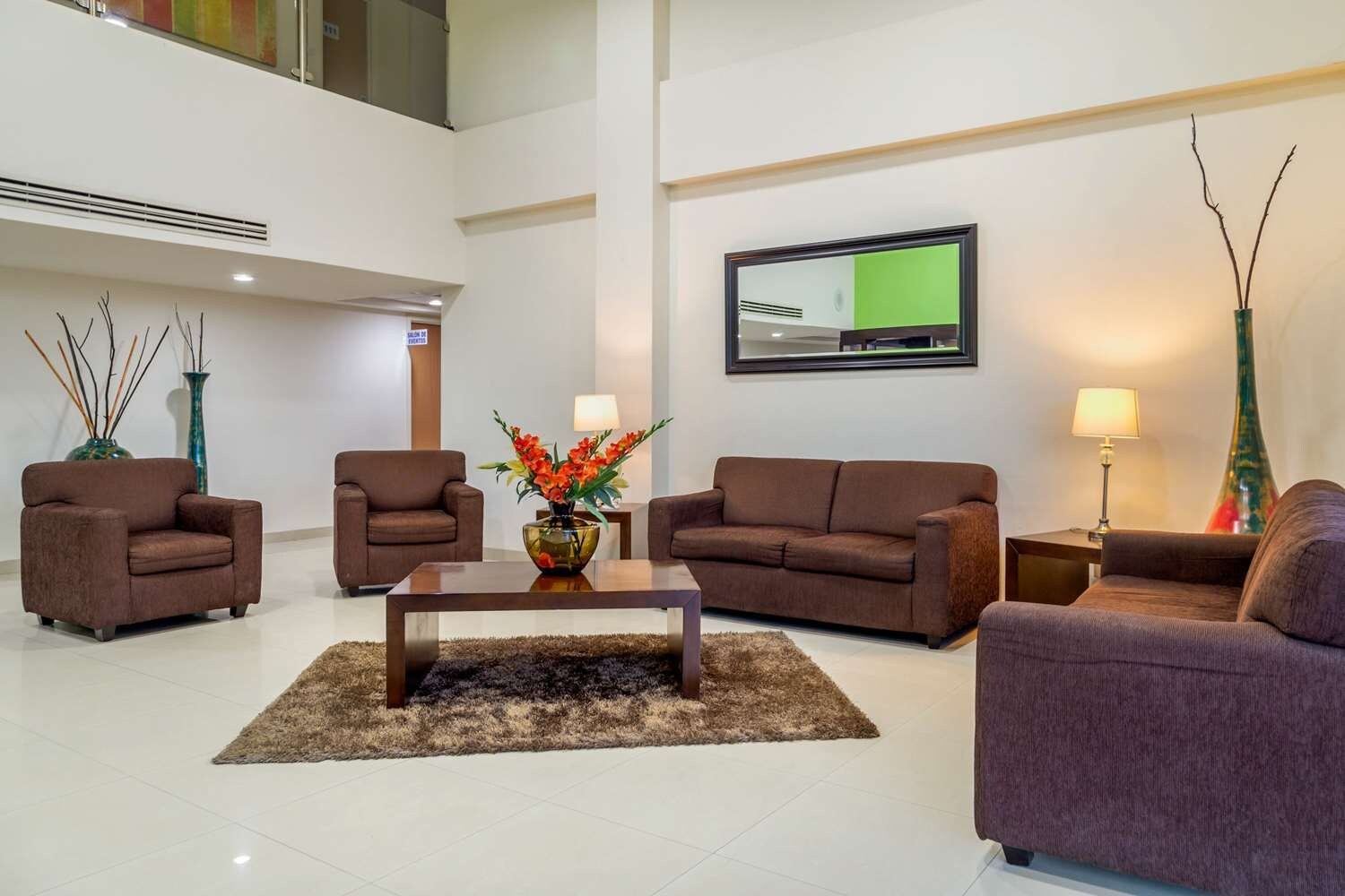Ein modernes Wohnzimmer mit einem Flachbildfernseher, zwei Sofas, einem Couchtisch und dekorativen Vasen.