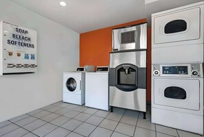 A laundry facility with a washing machine, a dryer, and a water dispenser.