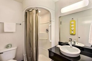 Ein Badezimmer mit Dusche, Toilette, Waschbecken und Spiegel.