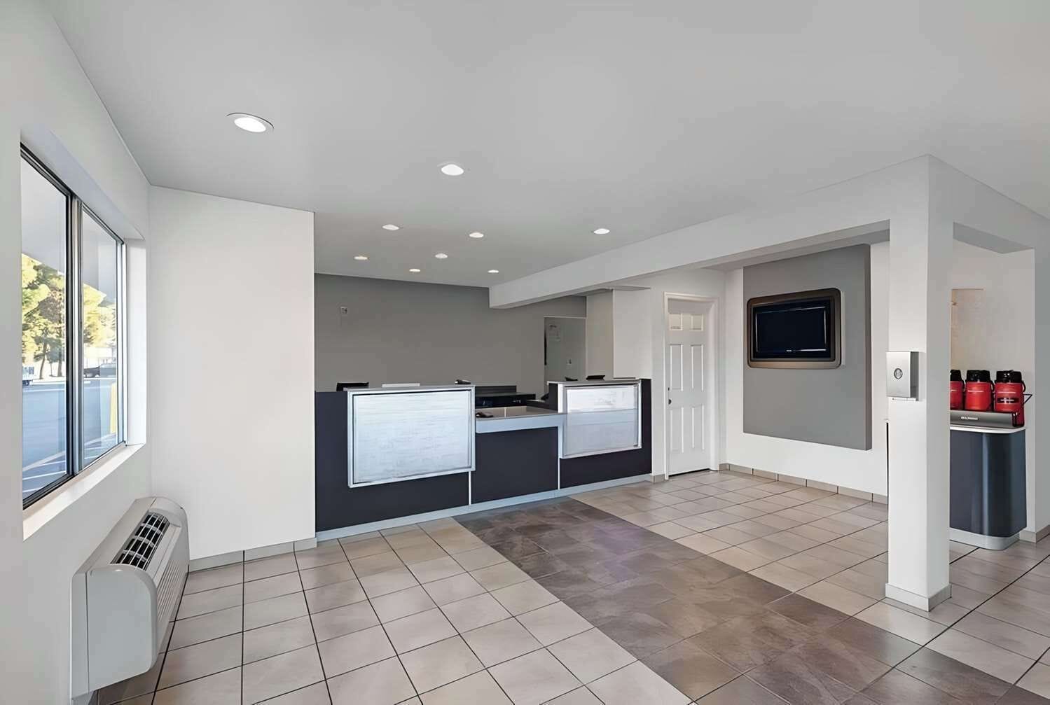 A modern kitchen with a large island, a built-in oven, and a microwave.