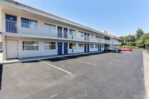 A motel with a parking lot, multiple rooms with blue doors, and a two-story structure. - Park Inn by Radisson, San Jose (San Jose)