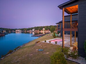 Une propriété située au bord de l’eau, dotée d’une terrasse couverte, d’un espace salon extérieur et d’une piscine.