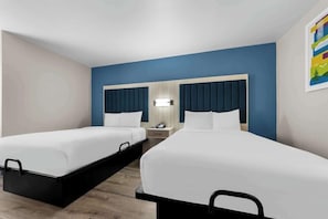 A hotel room with two single beds, a bedside table with a lamp, and a wall-mounted light fixture. - Park Inn by Radisson, Medical Center (San Antonio)