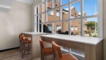 Eine moderne Küche mit großem Fenster, einer Holztresore und zwei Barhocker.