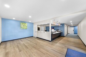 A hotel reception area with a blue wall, a reception desk, and a wooden floor. - Park Inn by Radisson, Medical Center (San Antonio)