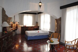 Ein Hotelzimmer mit einem Bett, einem Schreibtisch, einem Sessel, einem Tisch und einer Lampe.