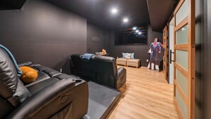 Un salon moderne avec un canapé en cuir, un petit divan et un plancher en bois.