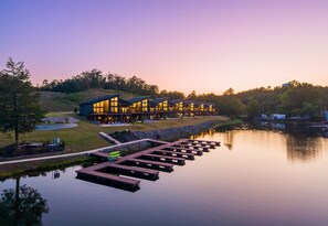 Eine am See gelegene Lodge mit mehreren Gästezimmern, einem Steg und einem friedlichen See.