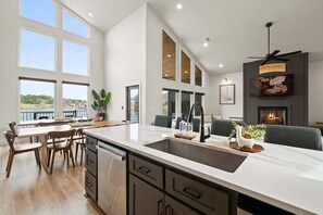 Eine moderne Küche mit einer großen Kochinsel, Essbereich und Kamin.