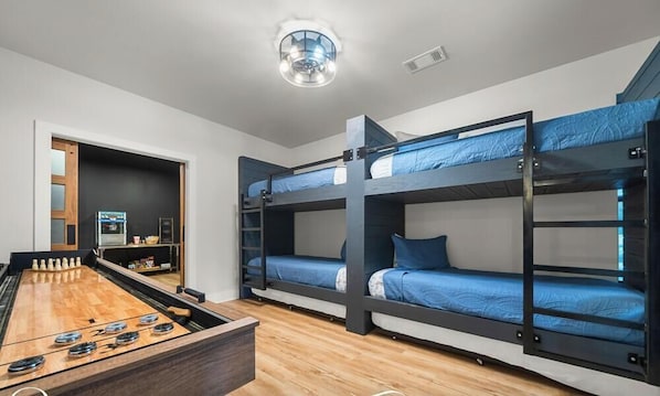 A room with bunk beds, a foosball table, and a kitchenette. - The Great Escape - 1 (Hot Springs)