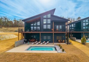 A modern two-story building with a swimming pool, outdoor seating, and a view of the surrounding landscape. - The Great Escape - 1 (Hot Springs)