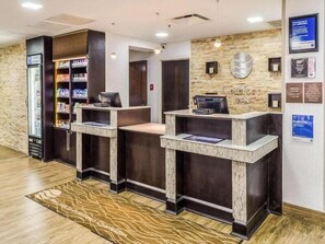 A reception area with a counter, a refrigerator, and a wall-mounted TV. - Comfort Inn Downtown Charleston (Charleston)