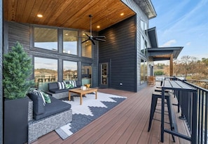 Eine moderne Terrassenanlage im Freien mit einer Sitzecke, einem Couchtisch und einem Essbereich.