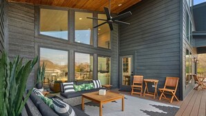 A modern outdoor living area with a sofa, chairs, a table, and a ceiling fan. - Private Pool, Dock, Movie Room on Lake Hamilton (Hot Springs)