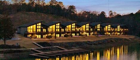 A row of modern, multi-story buildings with large windows, situated by a body of water.