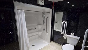 A modern bathroom with a glass-enclosed shower, a white toilet, and a marble backsplash. - Staindrop Lodge Hotel (Sheffield)