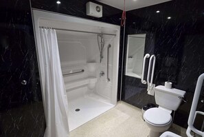 Une salle de bain moderne avec une douche à parois de verre, des toilettes blanches et un pare-baignoire en marbre.