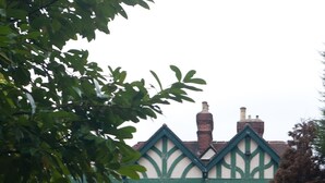 A brick building with a green and white facade, a sign reading 'STAINDROP HOTEL,' and a small porch with a bench. - Staindrop Lodge Hotel (Sheffield)