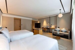 A modern hotel room with two beds, a desk, a sofa, and a TV. - Nantong Xinghu Hotel (Nantong)