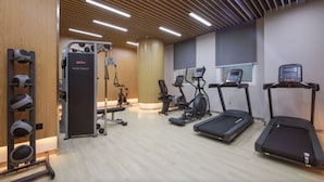 Ein Fitnessstudio mit Laufbändern, Crosstrainern und Krafttrainingsgeräten.