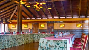 Un salón de conferencias con largas mesas, sillas e iluminación colgante.