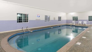 An indoor swimming pool with a tiled floor, a no diving sign, and a no lifeguard on duty sign. - Microtel Inn & Suites By Wyndham Windham (Windham)