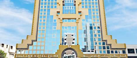 A hotel with a symmetrical facade, large windows, and a central entrance.