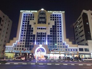 Un hotel de varios pisos con un letrero llamativo que dice 'CITY STAR HOTEL'.