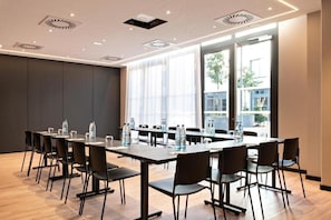 A conference room with a long table, chairs, and water bottles. - Leonor Hotel (Strasbourg)