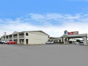 A building with a gas station attached, featuring a large sign, multiple parking spaces, and a few cars parked in front. - Americas Best Value INN Beaumont TX (Beaumont)