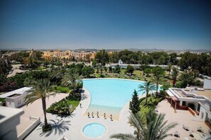 A resort with a large pool, palm trees, and a view of distant mountains. - TMK L Atrium Yasmine Hammamet (Hammamet)