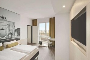 A hotel room with two beds, a desk, a chair, a large window with curtains, and a wall-mounted TV. - Premier Inn Hamburg City Berliner Tor (Hamburg)