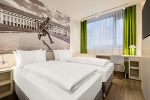A hotel room with a bed, a desk, a chair, a TV, and a window with curtains. - Premier Inn Koblenz City (Koblenz)